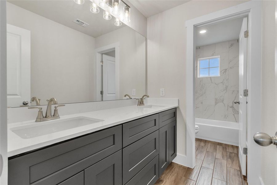 Double vanity in this pristine bathroom offers ample counter space and storage.