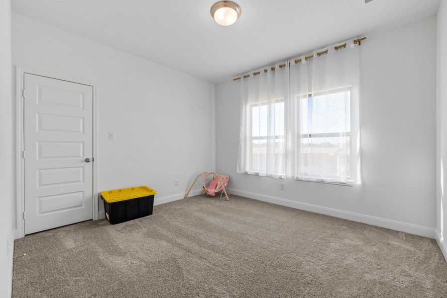 Unfurnished room featuring light carpet and baseboards