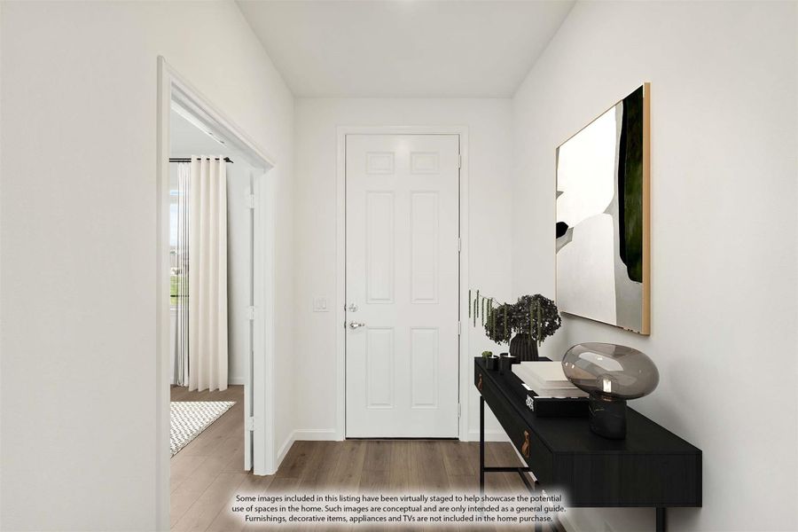 Narrow entryway hallway with white walls, wood-look floors, black console table, and framed wall art