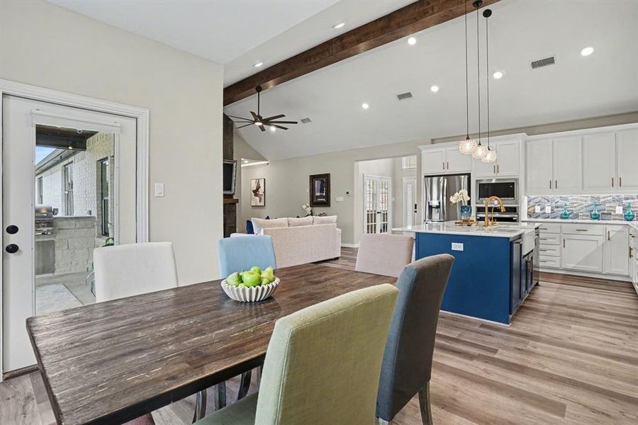 Dining room featuring vaulted ceiling, ceiling fan, and light wood-type flooring