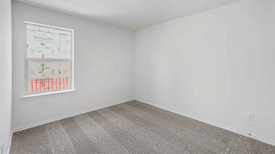 Bright room featuring a single window, light gray carpeting, white walls, and matching white baseboards