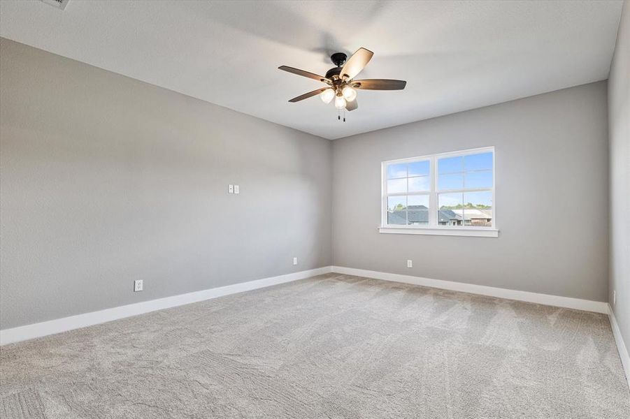 Unfurnished room featuring ceiling fan and carpet