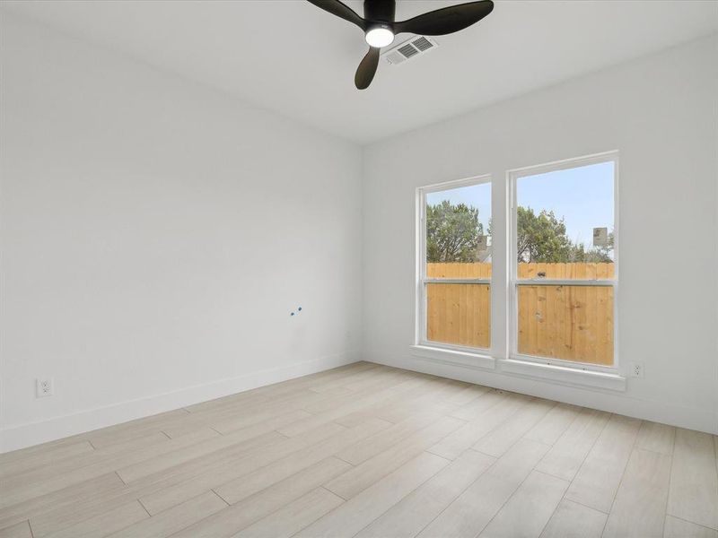 Unfurnished room with ceiling fan and light hardwood / wood-style floors