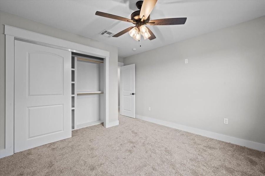 Unfurnished bedroom featuring carpet, a closet, and ceiling fan