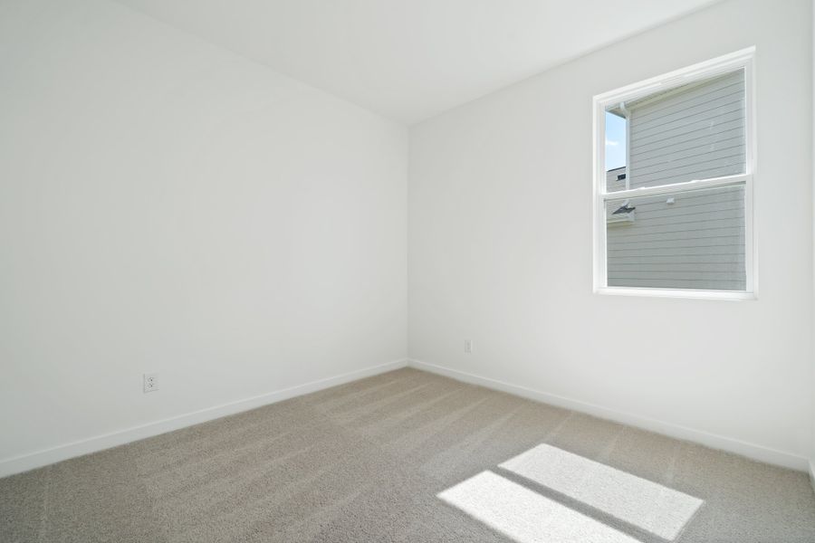 A room with a window and a rug.