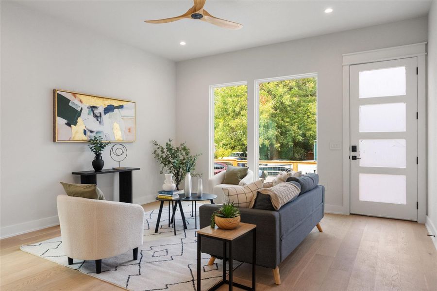 Living room featuring light wood-style flooring, recessed lighting, and a ceiling fan Living room featuring light wood-style flooring, recessed lighting, and a ceiling fan
