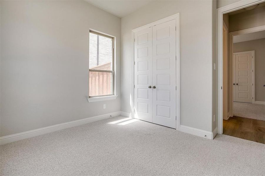 Unfurnished bedroom featuring carpet and multiple windows