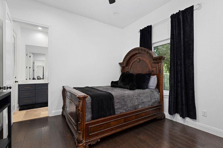 Bedroom featuring dark wood-type flooring, ensuite bath, and ceiling fan Bedroom featuring dark wood-type flooring, ensuite bath, and ceiling fan