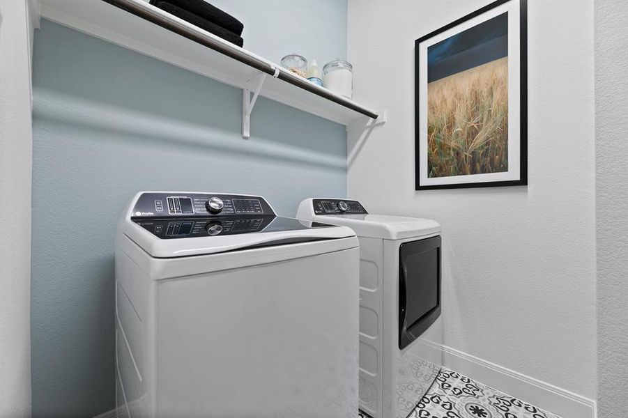Laundry room with separate washer and dryer and a textured wall Laundry room with separate washer and dryer and a textured wall