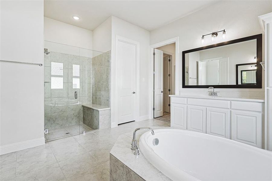 Bathroom featuring separate shower and tub and vanity