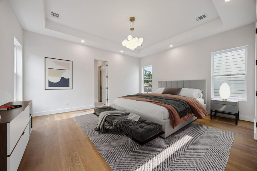 The primary suite feels spacious and open with elevated ceilings, oversized windows, and wide-plank flooring throughout. Natural light moves across the room during the day while the layout still leaves space for additional seating or furniture placement. (digitally staged) The primary suite feels spacious and open with elevated ceilings, oversized windows, and wide-plank flooring throughout. Natural light moves across the room during the day while the layout still leaves space for additional seating or furniture placement. (digitally staged)
