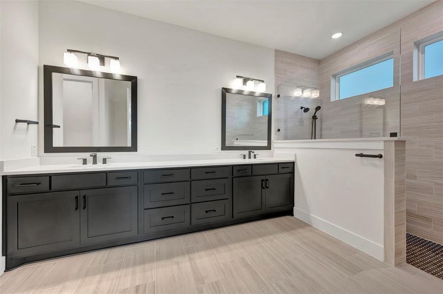 Owners Bath  featuring double vanity and a walk in shower
