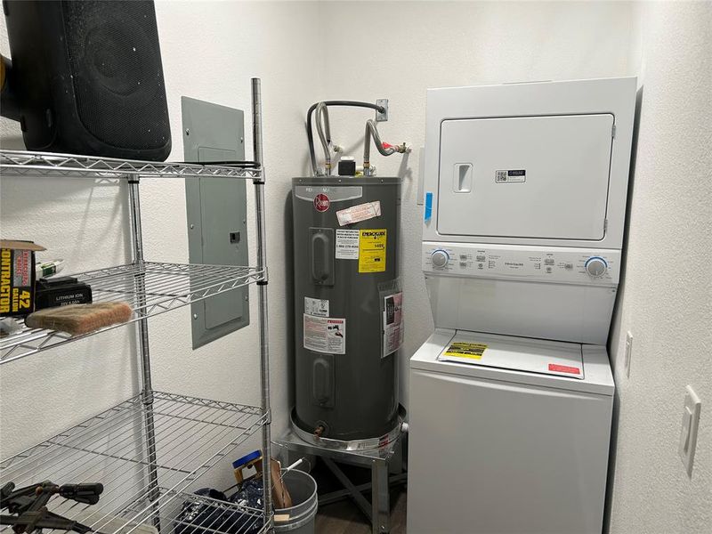 Utilities with water heater, electric panel, and stacked washer and clothes dryer Utilities with water heater, electric panel, and stacked washer and clothes dryer