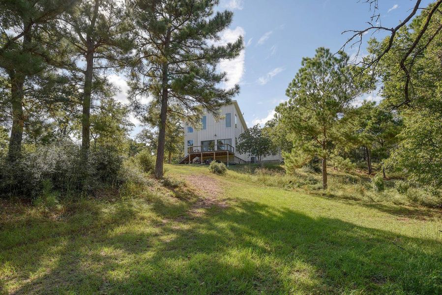 View of grassy yard with stairway and view of scattered trees View of grassy yard with stairway and view of scattered trees