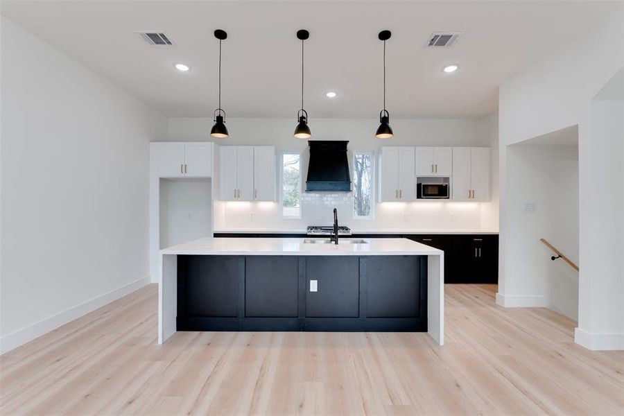 Black and white soft closing cabinets with waterfall calacatta gold countertops