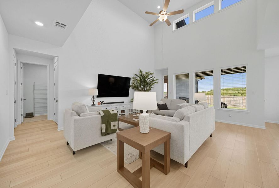 Living room featuring plenty of natural light, a ceiling fan, high vaulted ceiling, light wood finished floors, and recessed lighting Living room featuring plenty of natural light, a ceiling fan, high vaulted ceiling, light wood finished floors, and recessed lighting