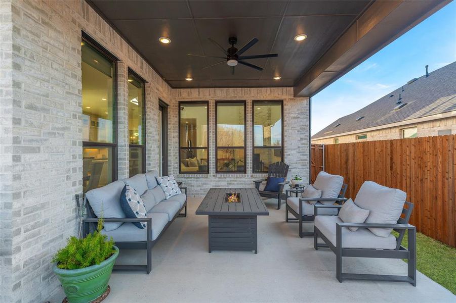 View of patio / terrace featuring an outdoor living space with a fire pit, fence, and ceiling fan