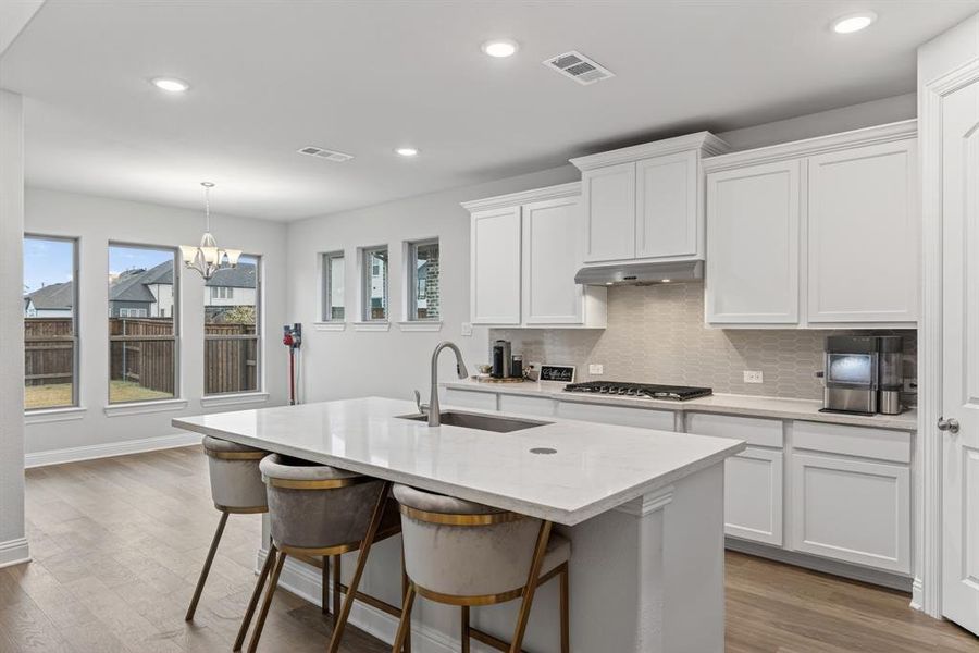 Kitchen featuring white cabinets, backsplash, dark wood-style floors, pendant lighting, and recessed lighting Kitchen featuring white cabinets, backsplash, dark wood-style floors, pendant lighting, and recessed lighting