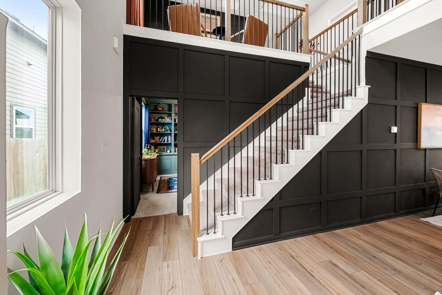 Staircase with a decorative wall and wood finished floors