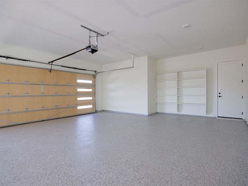 4-car garage with a epoxied floor and shelving.