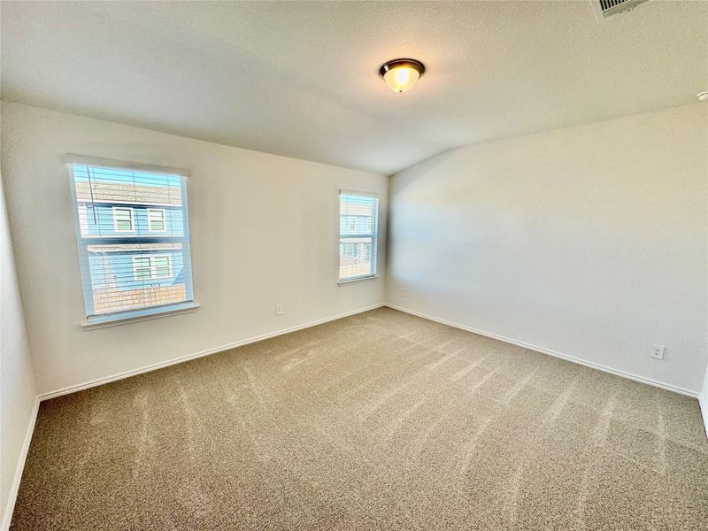 Carpeted empty room featuring vaulted ceiling and a textured ceiling