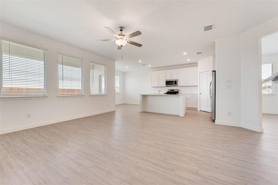 Unfurnished living room featuring light hardwood / wood-style flooring and ceiling fan