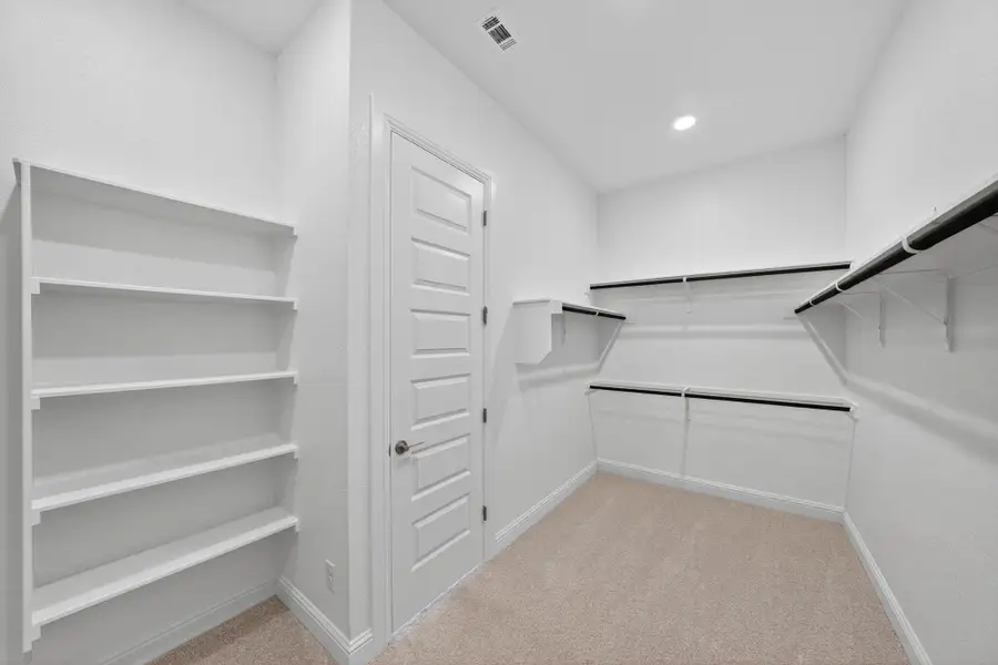 Spacious closet with light carpet Spacious closet with light carpet