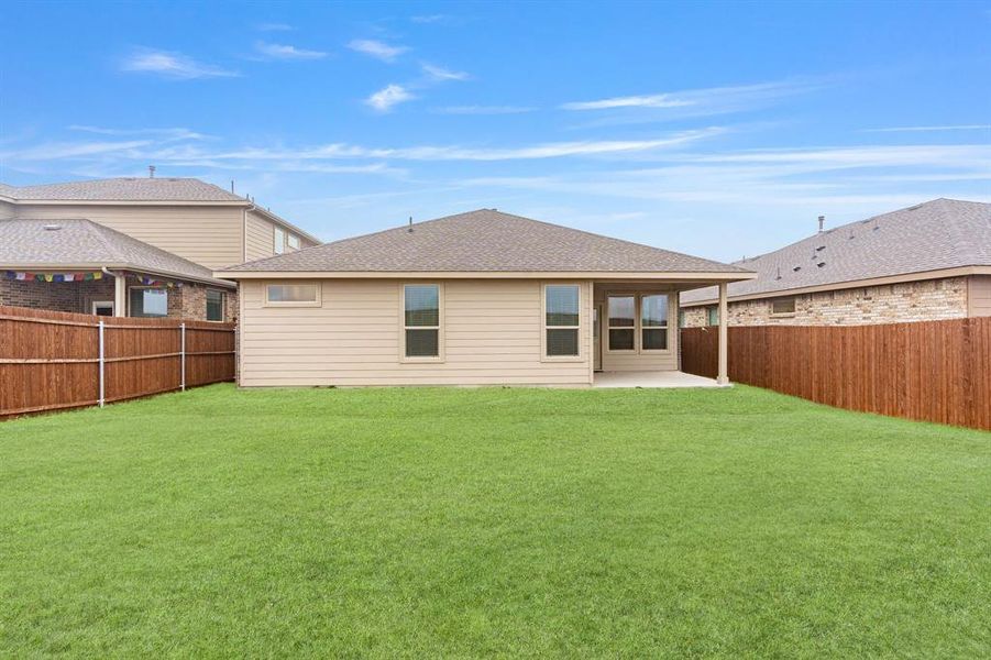 Rear view of house featuring a patio and a lawn