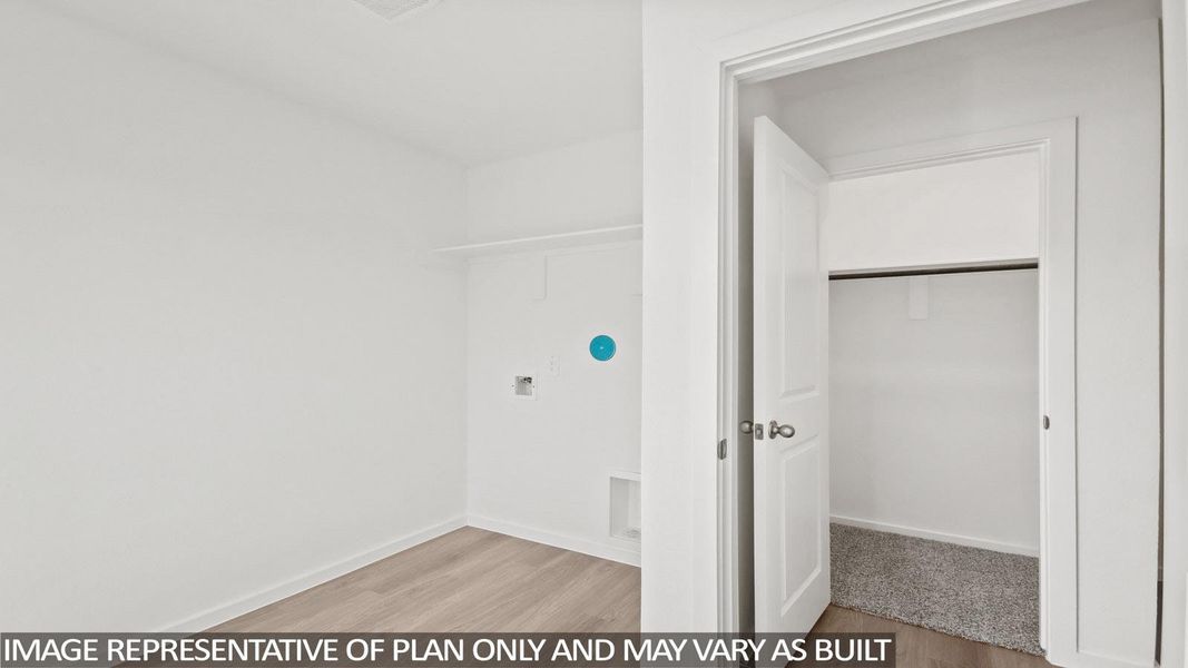 Utility area featuring wood-finish flooring and a laundry hookup with shelving
