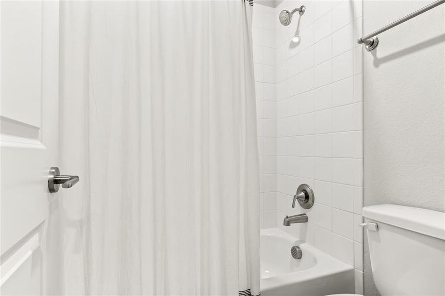 Bathroom with toilet and shower / bath combo with shower curtain