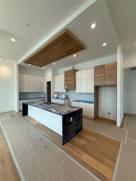 Kitchen featuring modern cabinets, a center island with sink, and recessed lighting Kitchen featuring modern cabinets, a center island with sink, and recessed lighting