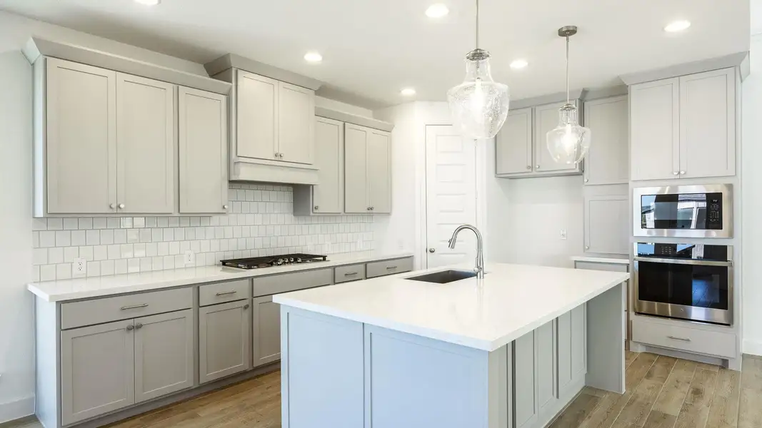 Kitchen featuring gray cabinetry, appliances with stainless steel finishes, recessed lighting, light wood-type flooring, and decorative backsplash