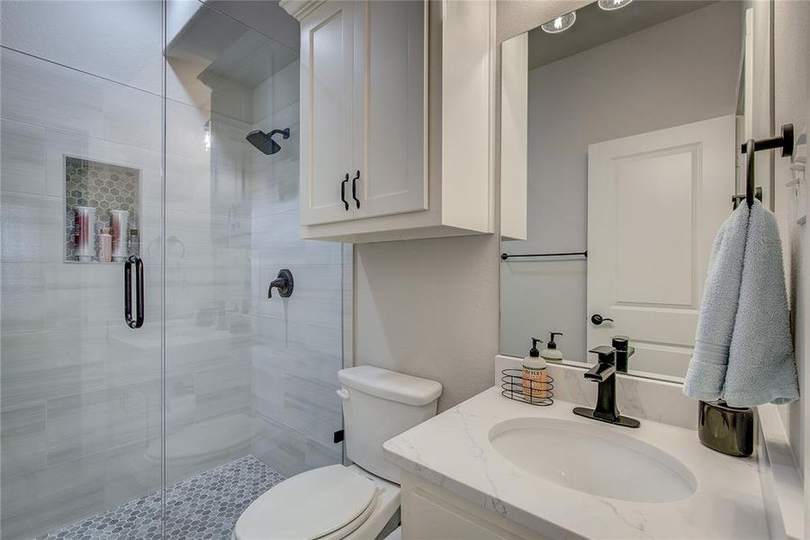 Bathroom featuring vanity, toilet, and walk in shower