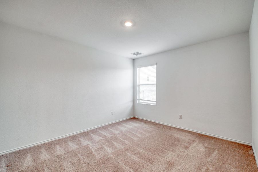 Neutral-toned room featuring a single window with blinds, recessed ceiling lighting, and carpeted flooring