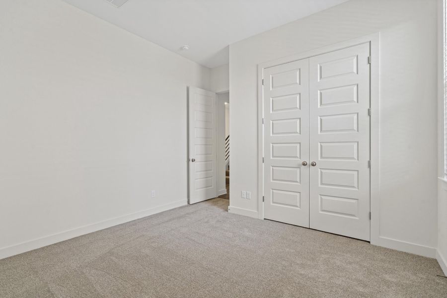Neutral-toned carpeting paired with white walls, baseboards, and trim