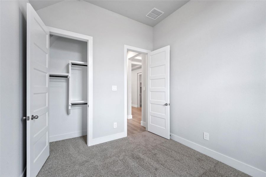 The secondary closet offers built in shelving and multiple rows to hang clothing.