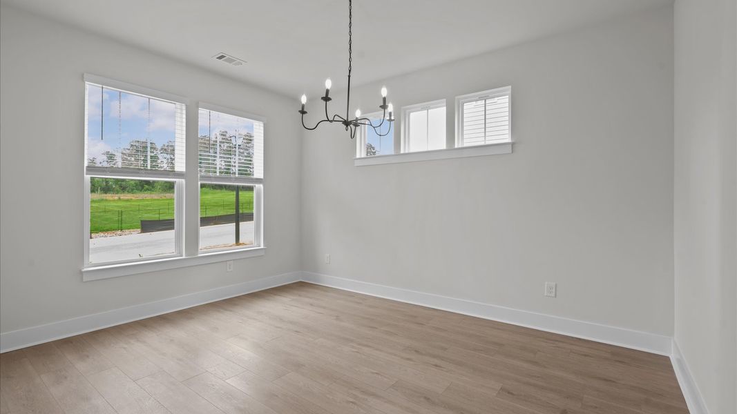 Dining room with stunning chandelier in two story townhome at Aspen Ridge by DRB Homes in Lyman, SC Dining room with stunning chandelier in two story townhome at Aspen Ridge by DRB Homes in Lyman, SC