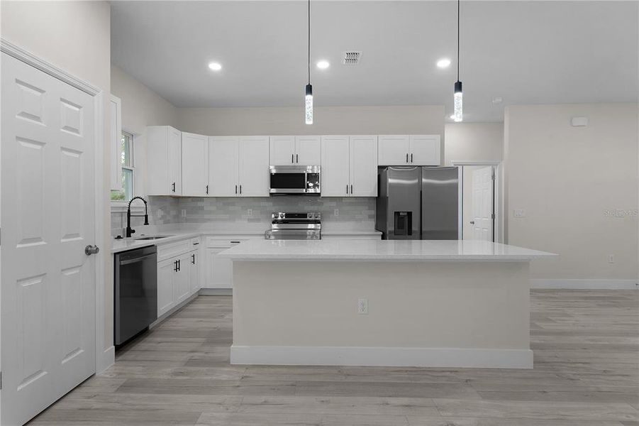 Looking at the kitchen from the dining area, with pantry closet door on the left