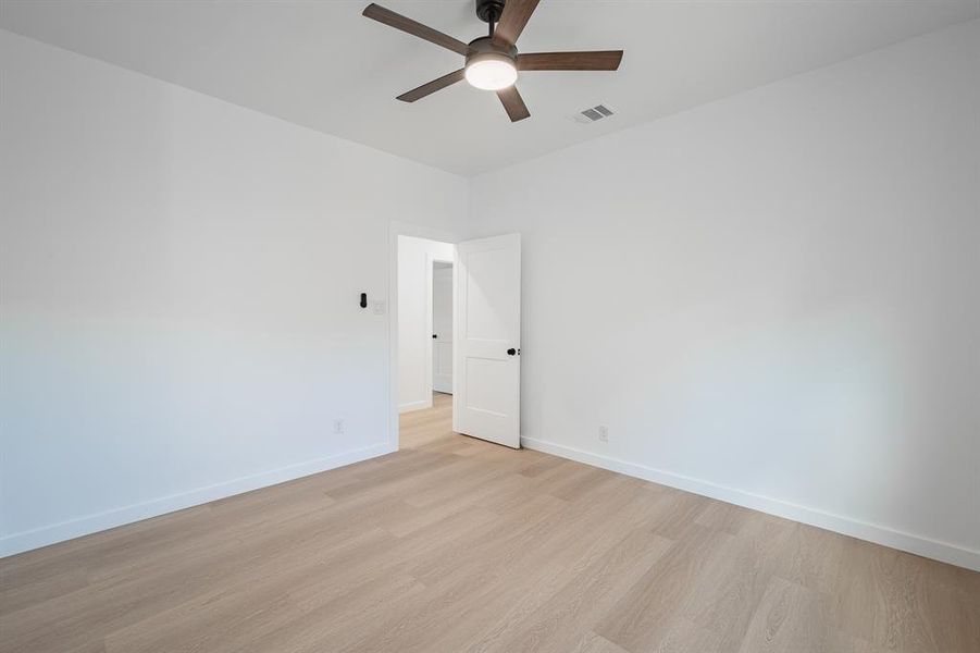 Spare room with light wood-style flooring and a ceiling fan Spare room with light wood-style flooring and a ceiling fan