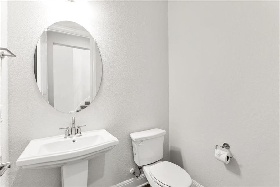 Half bath with toilet and a textured wall