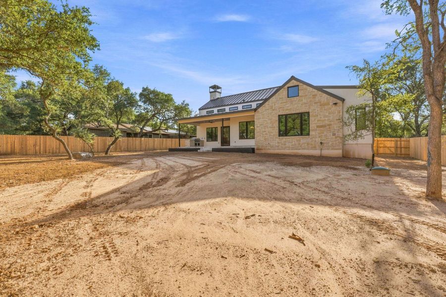 A stone and stucco exterior pairs beautifully with a metal roof and covered patio.