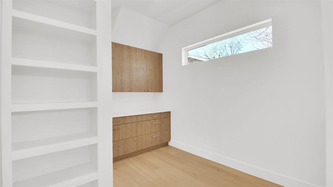 Primary suite closet with custom built-in cabinets with direct access to laundry room