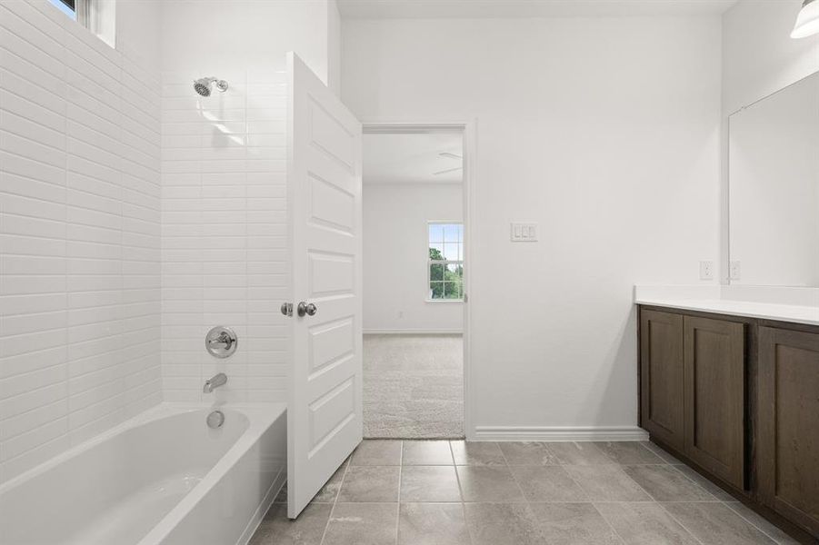 Bathroom with vanity, tiled shower / bath combo, and tile patterned floors