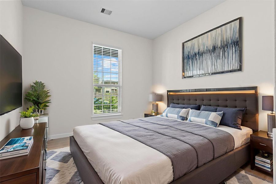 Virtually staged guest bedroom showcasing how easily the space can be transformed into a relaxing retreat with room for a bed, side tables, and décor.  All the guest bedrooms all have wonderful walk in closets for everyone storage needs.