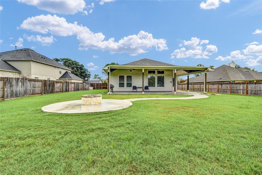 Oversized backyard showcasing the wrap around covered patio and a built in firepit with walkway Oversized backyard showcasing the wrap around covered patio and a built in firepit with walkway