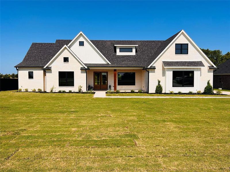 Modern farmhouse featuring a front lawn