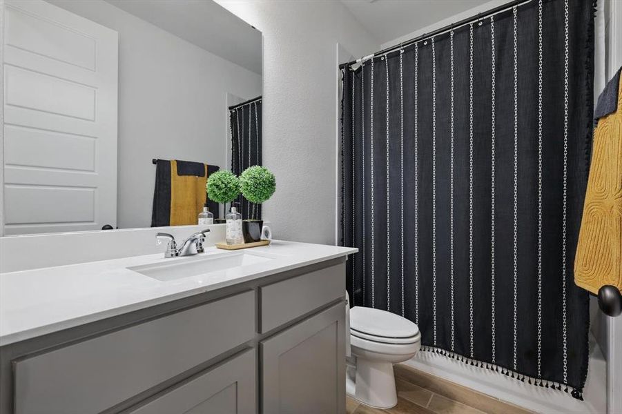 Bathroom featuring vanity, toilet, and wood finished floors