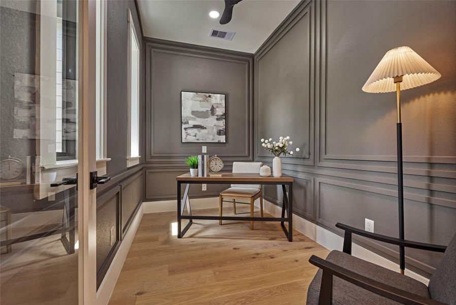 Sophisticated private study with floor-to-ceiling picture-frame wall molding, glass French doors, and white oak hardwood floors — a moody, design-forward space made for working from home. Sophisticated private study with floor-to-ceiling picture-frame wall molding, glass French doors, and white oak hardwood floors — a moody, design-forward space made for working from home.