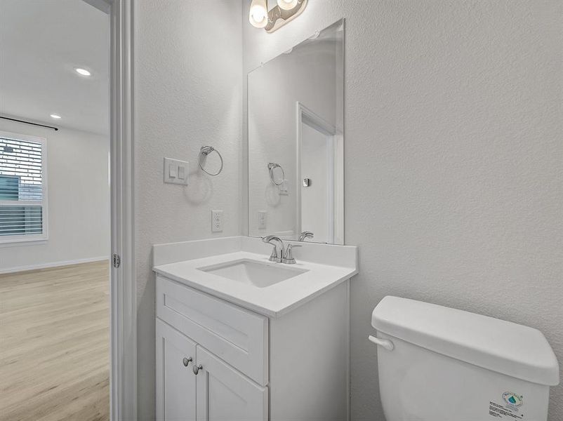 Bathroom featuring hardwood / wood-style floors, vanity, and toilet