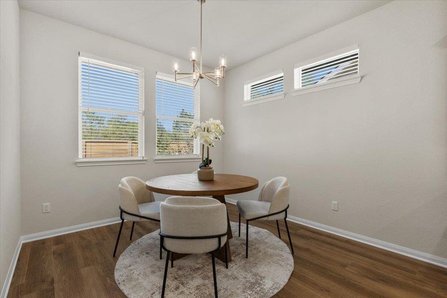 The dining area is bathed in natural light and framed by tree-lined views.
